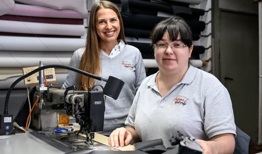 Mainpost-2025-11-12 Anna Meusert und ihre Mitarbeiterin Nataliia Yakushyna bei Planen Wehner in Schweinfurt vor Industrienähmaschine, erfolgreiche Arbeitsintegration von Ukrainerinnen.
